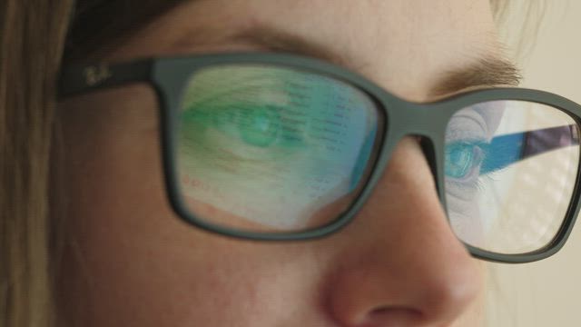 Reflection of a screen in glasses.