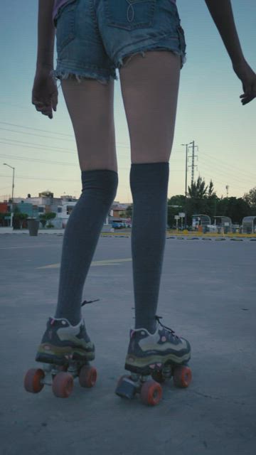 Young woman skating slowly in a parking lot.