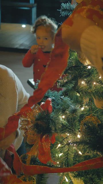 Father and mother decorating a Christmas tree.