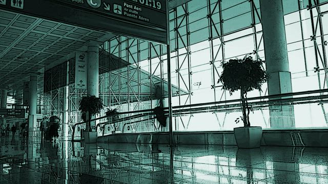 People walking down an airport corridor in fast motion.