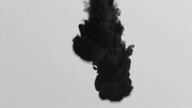 Black ink enter a transparent liquid medium with force creating a mesmerizing spectacle.