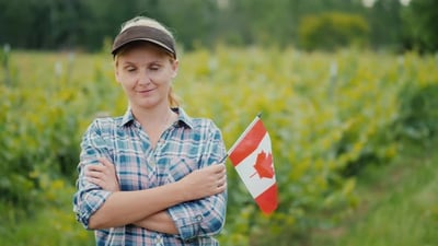 Woman Farmer with Canadian Flag Looking at the Camera.