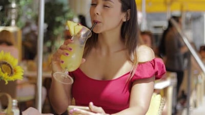 Smiling Woman with Smartphone in Outside Cafe.