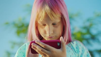 Portrait of Cool Girl with Pink Hair Is Talking Through a Smart Watch.