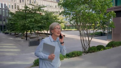 Caucasian Business Woman Senior 50s Businesswoman Running in City Business Downtown Smiling Happy.