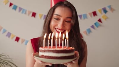 Cheerful Woman Holding Birthday Cake with Lit Candles.