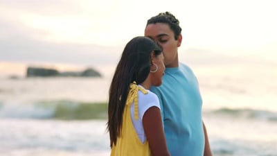 Love, kiss and a couple walking on the beach together for romance on their anniversary.