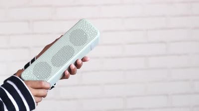 Man's Hand Holding a Smart Speaker with Copy Space.