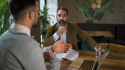 Two businessman having a business meeting in cafe..