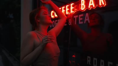 Energetic City Vibes Young Woman Smiles and Dances with Joy in the RedLit City Center.